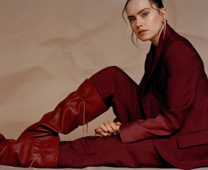 Daisy Ridley sitting down while wearing an all red Roksanda suit