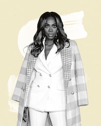 Actor & Comedian Yvonne Orji wearing a white suit and a pink checked coat over her shoulders
